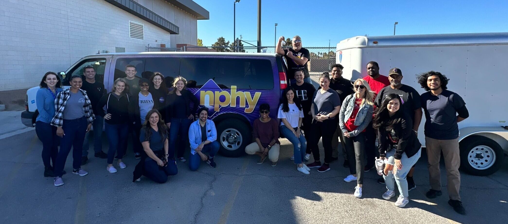 Fellows gather for a photo in front of an NPHY van after participating in Feel Good Friday at the organization